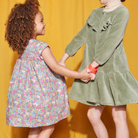Little Girls seen wearing our Charlotte Dress in Merion Floral (left) and our Western Dress in sage Green (on right)--BISBY girls