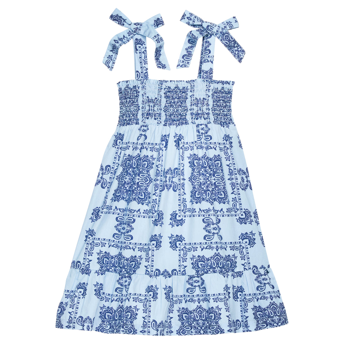 BISBY girl woven dress in a light blue/navy blue bandana print. Dress features wide straps with faux bow tie feature, smocking across bust, and bottom tier feature for an elevated look.