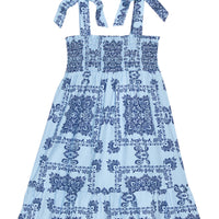 BISBY girl woven dress in a light blue/navy blue bandana print. Dress features wide straps with faux bow tie feature, smocking across bust, and bottom tier feature for an elevated look.