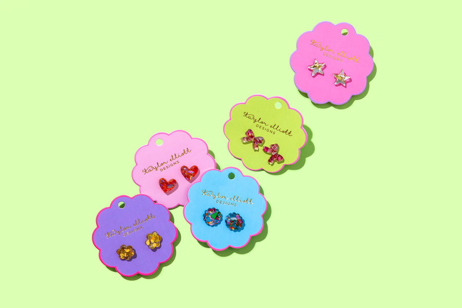 Colorful earring display cards with earrings on a light green background
