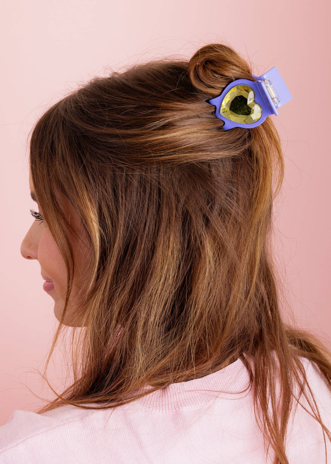 Woman with a hair heart hair clip on a pink background