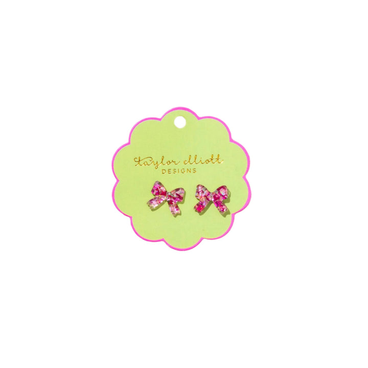 Green card with pink bow earrings on a white background