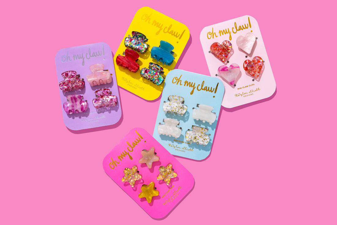 Set of colorful hair clips in packaging on a pink background