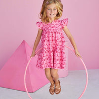 Young girl wearing pink eyelet dress from BISBY.