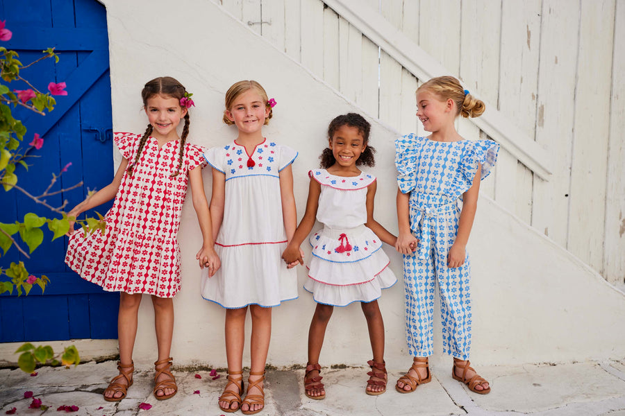 tween girls tiered mini skirt with blue and pink embroidery and pink and blue pom pom trim