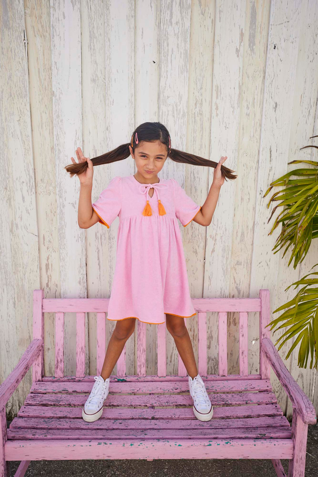 tween girls pink terry cloth dress with orange trim and orange tassels