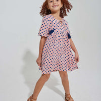 tween girls pink and navy geo print dress with scalloped sleeves and navy tassels
